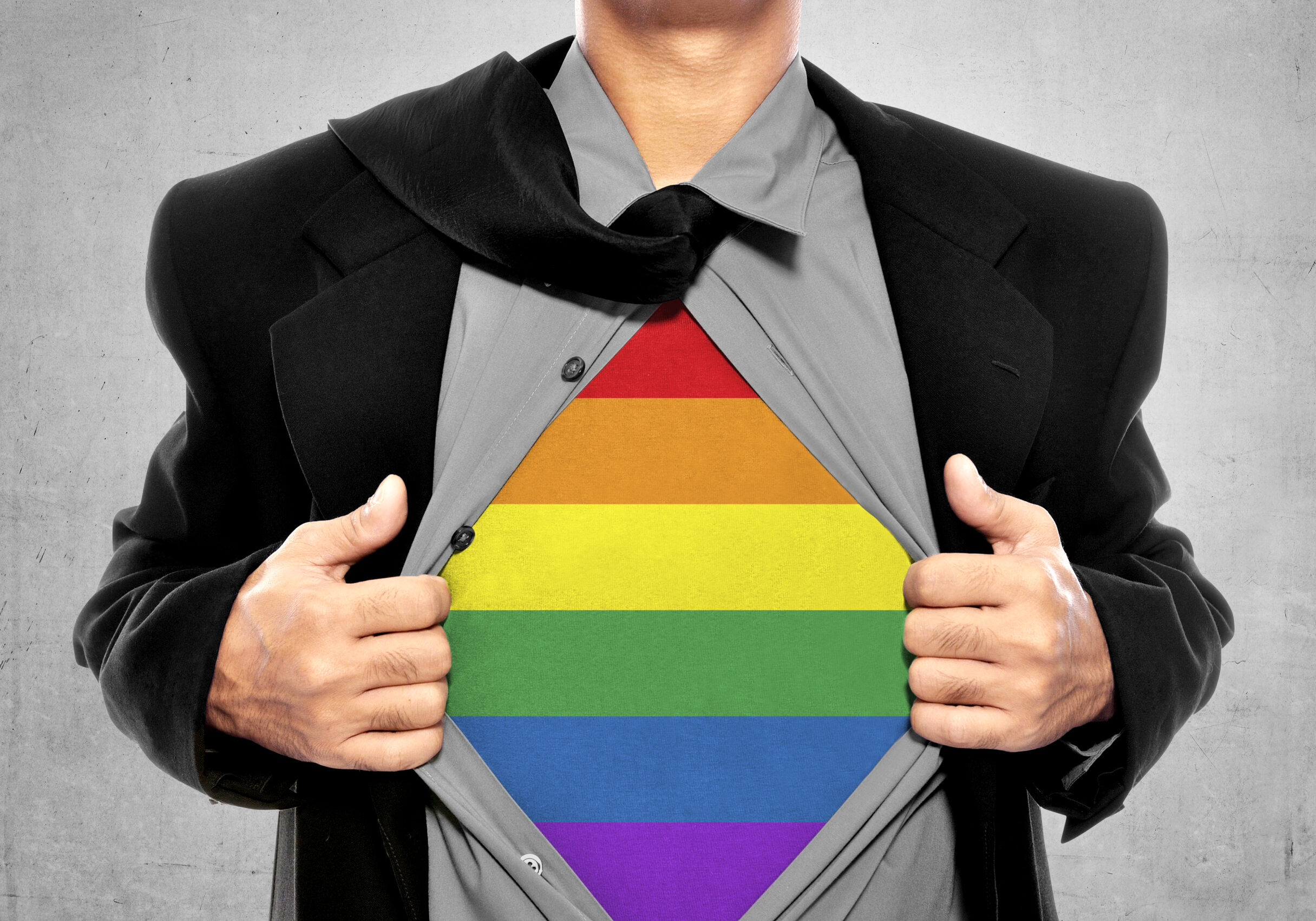 Business man tears open his shirt in a super hero fashion getting ready to save the day. LGBT freedom conceptual